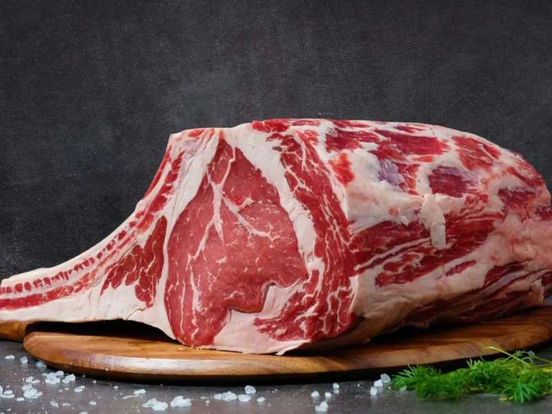 Raw bone-in beef rib on a board